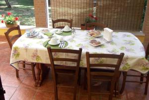 瓦尔蒙托内卡斯塔涅托Al住宿加早餐旅馆的一张桌子,上面有白色的桌布,椅子上还有食物
