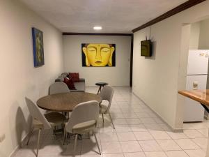 蒙特雷Departamento en Paseo Santa Lucía con Terraza D2的一间设有桌子的用餐室,墙上有黄色的面孔