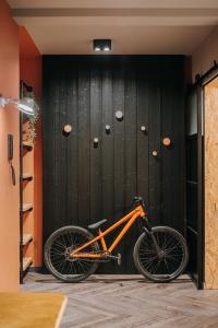 别尔斯克-比亚拉Apartament Riders Lodge Bielsko-Biała Jeżynowa的一辆停放在黑墙前的橙色自行车