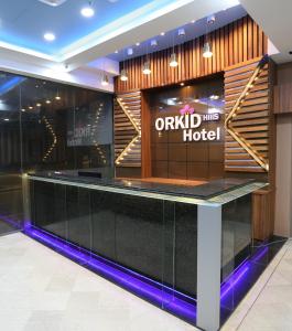 吉隆坡Orkid Hills Hotel的酒店大堂设有黑色柜台和酒店标志