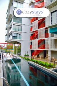 危地马拉Cozy Stays Cayala Apartments 7的建筑前的一座带游泳池的建筑