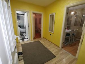 查查克Apartman Caroline的一间设有黄色墙壁的客房和一个带地毯的走廊