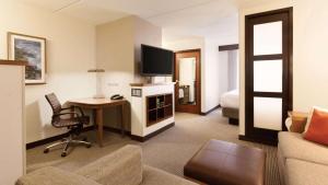 德卢斯Sonesta Select Atlanta Duluth的酒店客房配有书桌,客房则配有床