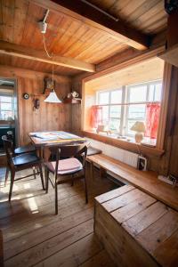 SkálavíkThe Real Faroese Experience的一间带桌椅和窗户的用餐室