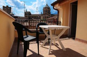 洛尼戈圣马可住宿加早餐旅馆的阳台上配有一张白色的桌子和两把椅子