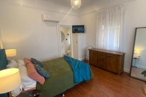 伊普斯维奇Urban Getaway Ipswich Central的一间卧室配有绿色的床和梳妆台