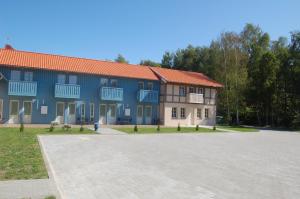 奈达Nidos stiegė的一座蓝色的大建筑,前面设有停车场