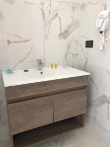 雷焦卡拉布里亚美丽之家公寓的浴室配有白色水槽和大理石墙壁。