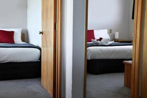提马鲁贝沃奇汽车旅馆旅舍的一间卧室配有两张带红白色枕头的床