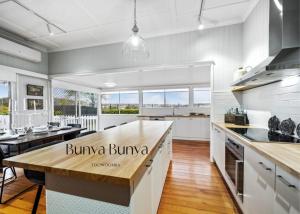 土乌巴Bunya Bunya Luxury Estate Toowoomba set over 2 acres with Tennis Court的厨房配有白色橱柜和木制台面