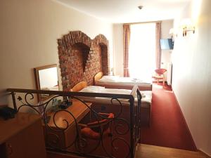 巴尔托希采巴提斯酒店的一间卧室设有一张床和砖墙