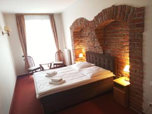巴尔托希采巴提斯酒店的砖墙房间的一个床位
