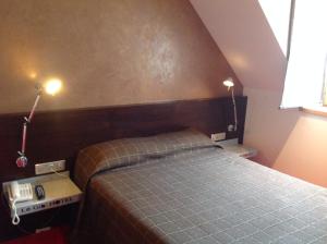 洛埃阿克拉吉贝希埃尔酒店的卧室配有一张床,墙上有两盏灯