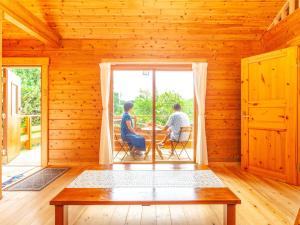 石垣岛石垣島コテージAkeeesi365的木房子里坐在桌子上的两个人
