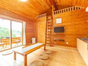 石垣岛石垣島コテージAkeeesi365的客房设有木墙、桌子和电视。