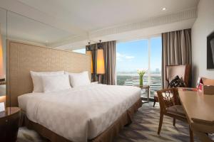雅加达卡里巴塔瑞士贝尔住宅酒店的配有一张床、一张书桌和一扇窗户的酒店客房