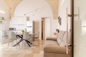 布林迪西[ApuliaLux] Marietta Luxury House - Centro Storico的厨房以及带沙发和桌子的客厅。