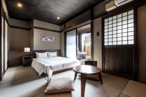 别府Beppu Nagomitsuki的卧室配有床、桌子和窗户。