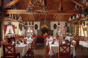 耶塞尼克十字山酒店的一间带桌椅和壁炉的用餐室