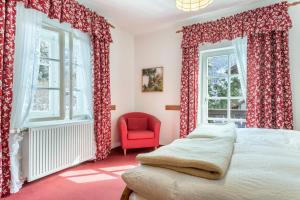 贝里斯泽尔Voglsang - Haus Annamirl的一间卧室配有红色窗帘、一张床和红色椅子