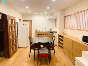 横滨Yokohama HY House的厨房配有桌椅和冰箱。