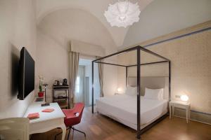 佛罗伦萨佛罗伦萨罗萨港NH精选酒店的卧室配有白色的床和桌椅