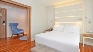 巴塞罗那巴塞罗那勒哥尔特NH酒店的一间卧室配有一张床和一张蓝色椅子