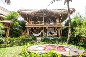SelatMagic Hills Bali - Magical Eco-Luxury Lodge的前面有池塘的房子
