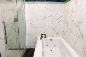 比洛克西Wingate by Wyndham Biloxi - Ocean Springs的白色的浴室设有浴缸和淋浴。