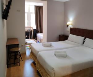 布尔戈斯奎塔米拉普埃布拉酒店的酒店客房设有两张床和窗户。