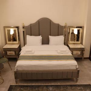 埃尔比勒Haden Hotel的一间卧室配有一张带两面镜子的大床