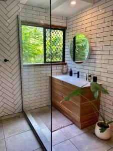 库兰达Tranquil Rainforest Studio Kuranda的带淋浴和盥洗盆的浴室以及窗户。