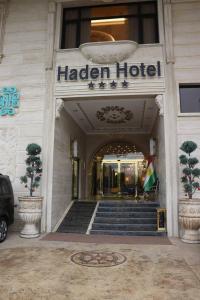 埃尔比勒Haden Hotel的门前有旗帜的酒店入口
