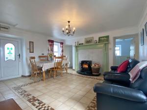 巴利康尼利Cottage 429 - Ballyconneely的带沙发、桌子和壁炉的客厅