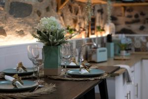 比索达雷加Salgueiral Guest House Douro的桌子,上面有盘子,玻璃杯,花瓶