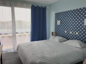 BuxyLes Songes de Buxy的一间卧室设有一张蓝色墙壁的大床