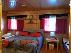 萨利色尔卡Tunturipöllö / Lapland, Saariselkä的一间卧室设有两张床和红色窗帘