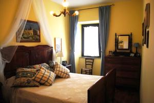 博尔塞纳The garden of history的一间卧室配有一张床、一个梳妆台和一扇窗户。