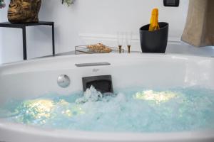 庞贝NM Luxury Suites的浴缸配有蓝色水和壁炉
