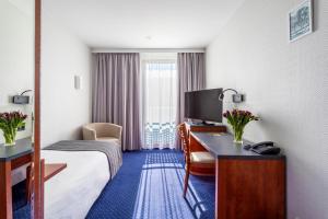 绿山城锡隆纳葛拉奎巴斯酒店的酒店客房设有一张床和一张带电视的书桌。