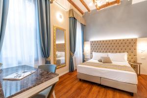 威尼斯Residenza La Duchessa Deluxe Rooms的一间卧室配有一张床、一张书桌和一面镜子