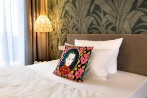 雷根斯堡Hotel Das Regensburg的一间卧室配有一张带枕头和墙壁的床