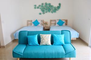 沙努尔Ocean Star Apartment Sanur的配有两张床的房间的蓝色沙发