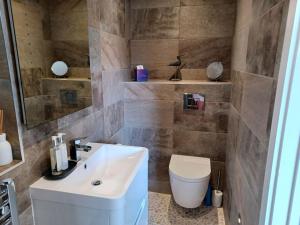 卡比斯贝Stylish coastal retreat in St Ives的浴室配有白色水槽和卫生间。