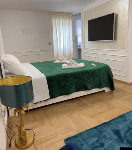罗马PARIOLI LUXURY SUITE的一间卧室配有一张带绿毯的床和一台电视