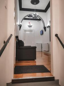 格拉斯哥S.H Apartments的走廊上设有1间带黑色沙发的客厅