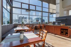 绿山城锡隆纳葛拉奎巴斯酒店的餐厅设有桌椅和大窗户。