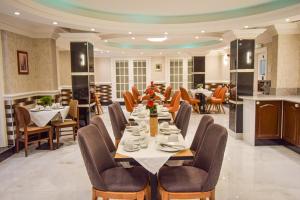 伦敦彭布里奇皇宫酒店的一间带长桌和椅子的用餐室
