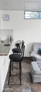 弗洛伦西亚Hermoso apartamento con servicios y garaje.的厨房配有2把黑色椅子和桌子