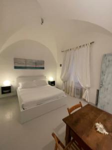 卡莫利La Casa di Alessia的白色卧室配有床和桌子